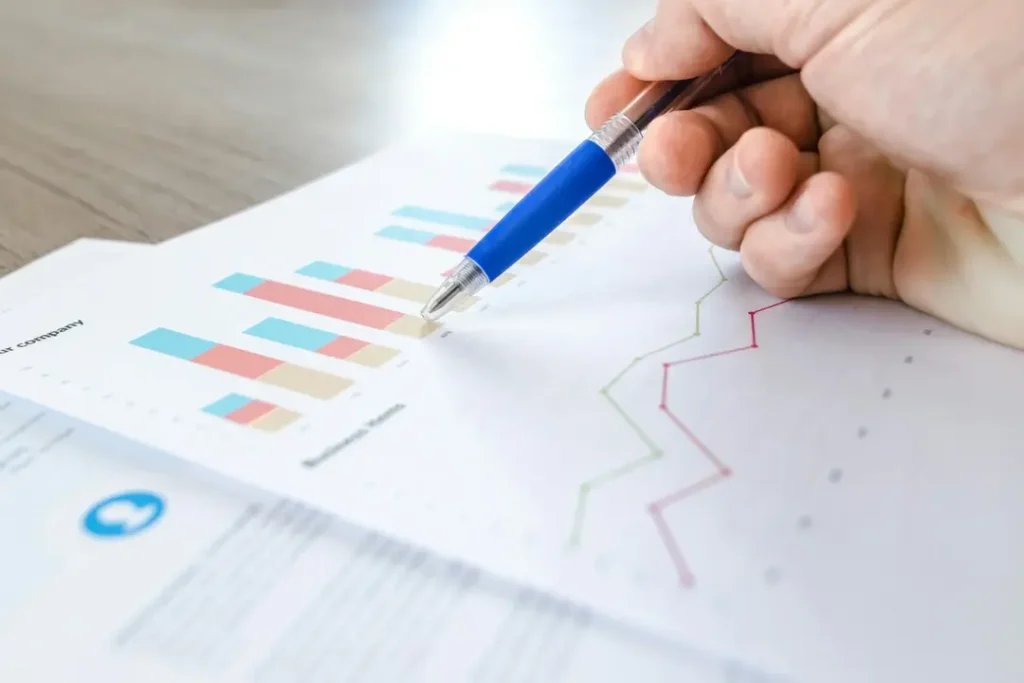 Data graph shown with a pen on hand pointing.