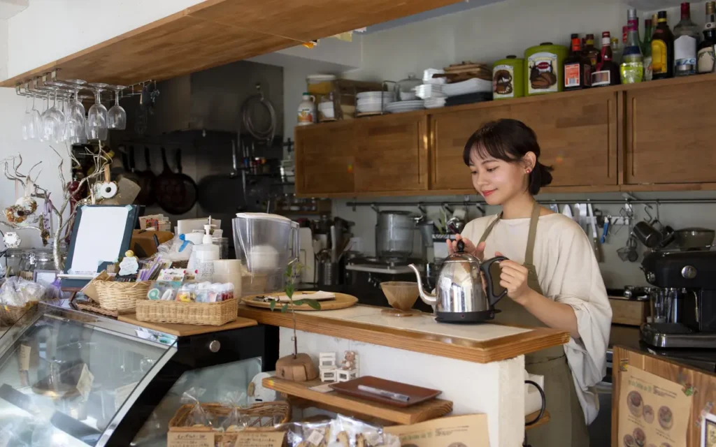 Coffee shop owner holding a kettle